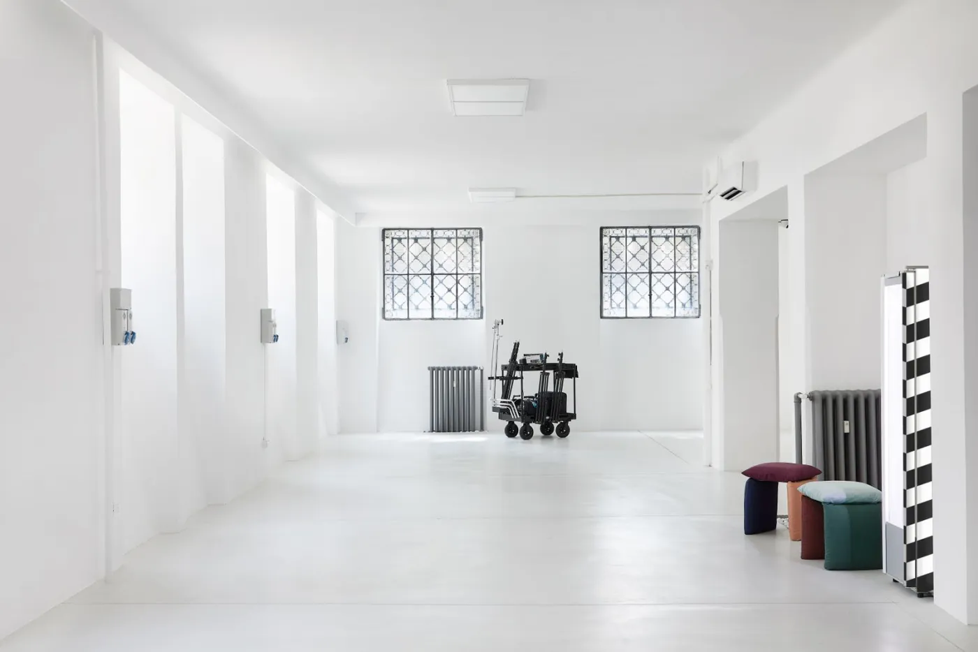 Bright interior with pale display fixtures and tall windows.