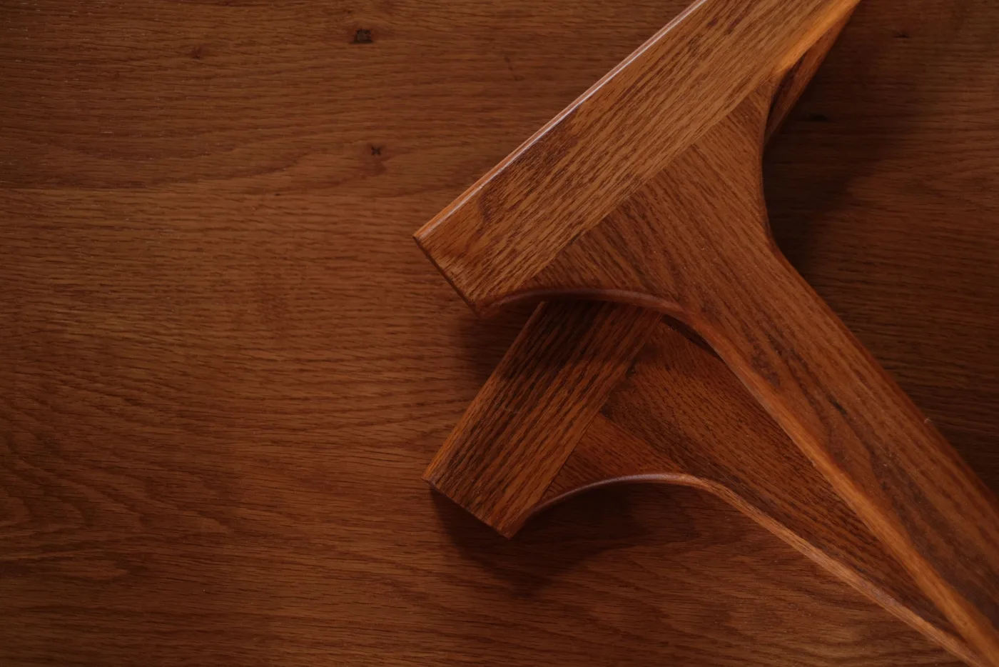 Detail of a carved wood furniture form on an oak surface.